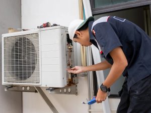 HVAC technician performing air conditioner repair on outdoor AC unit to restore cooling performance