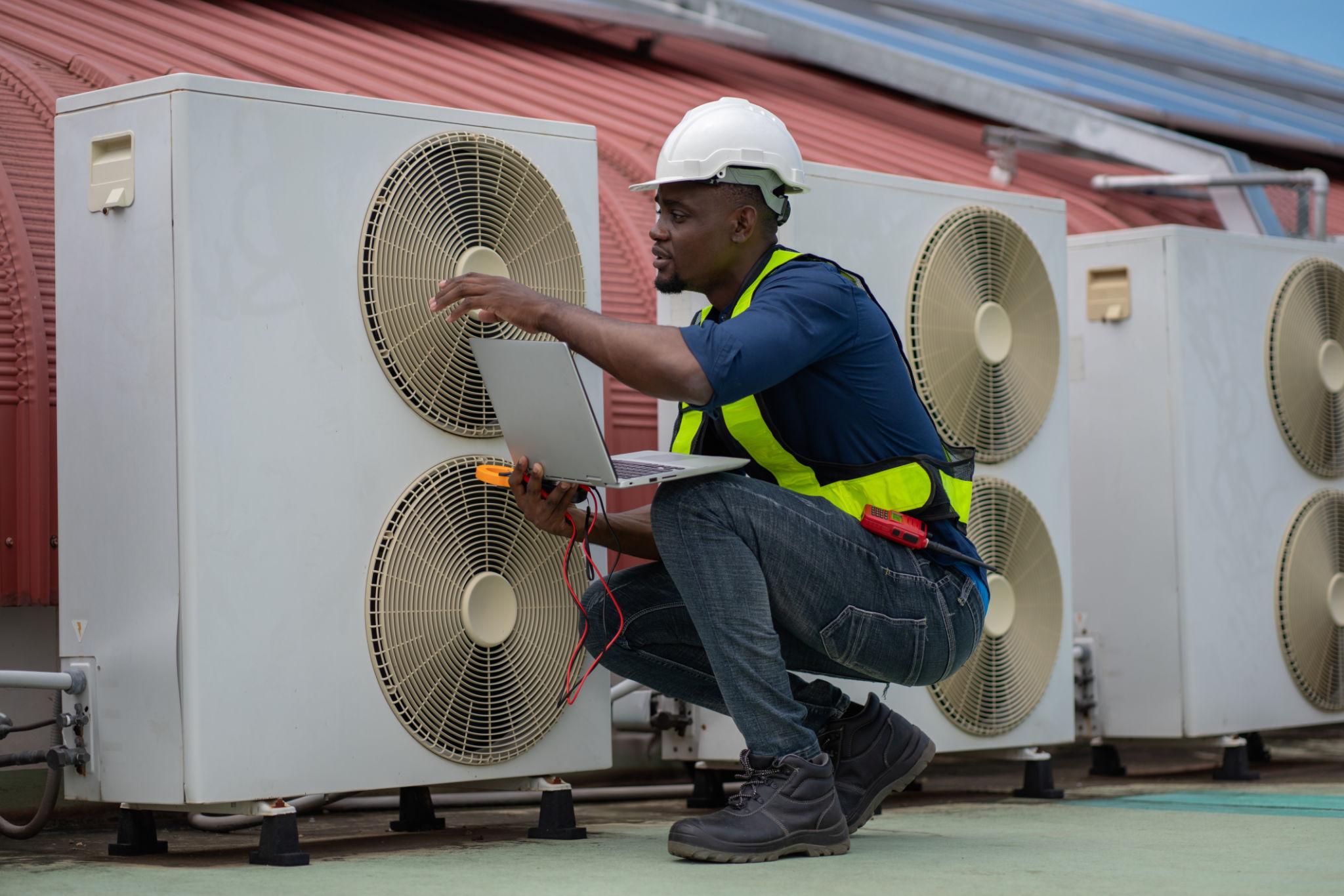 Industrial HVAC Solutions: Installation and Maintenance Tips from Experienced HVAC Technicians 1 Industrial HVAC technician performing rooftop unit maintenance for commercial clients